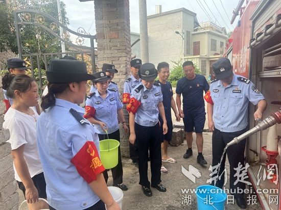 民輔警跟隨消防水車作業(yè)，通過肩挑手提的方式將清水送入行動不便的老年、殘障村民的家中（通訊員 李麗君 攝） (3).jpg.jpg