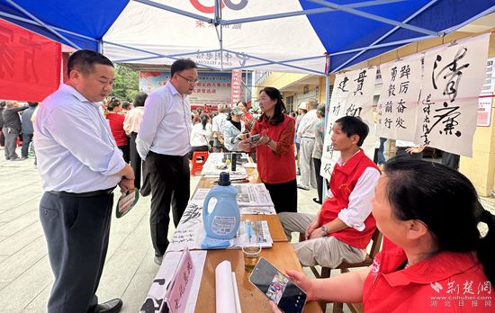 “文化惠民”攤位上，志愿者展示書法作品_副本.jpg